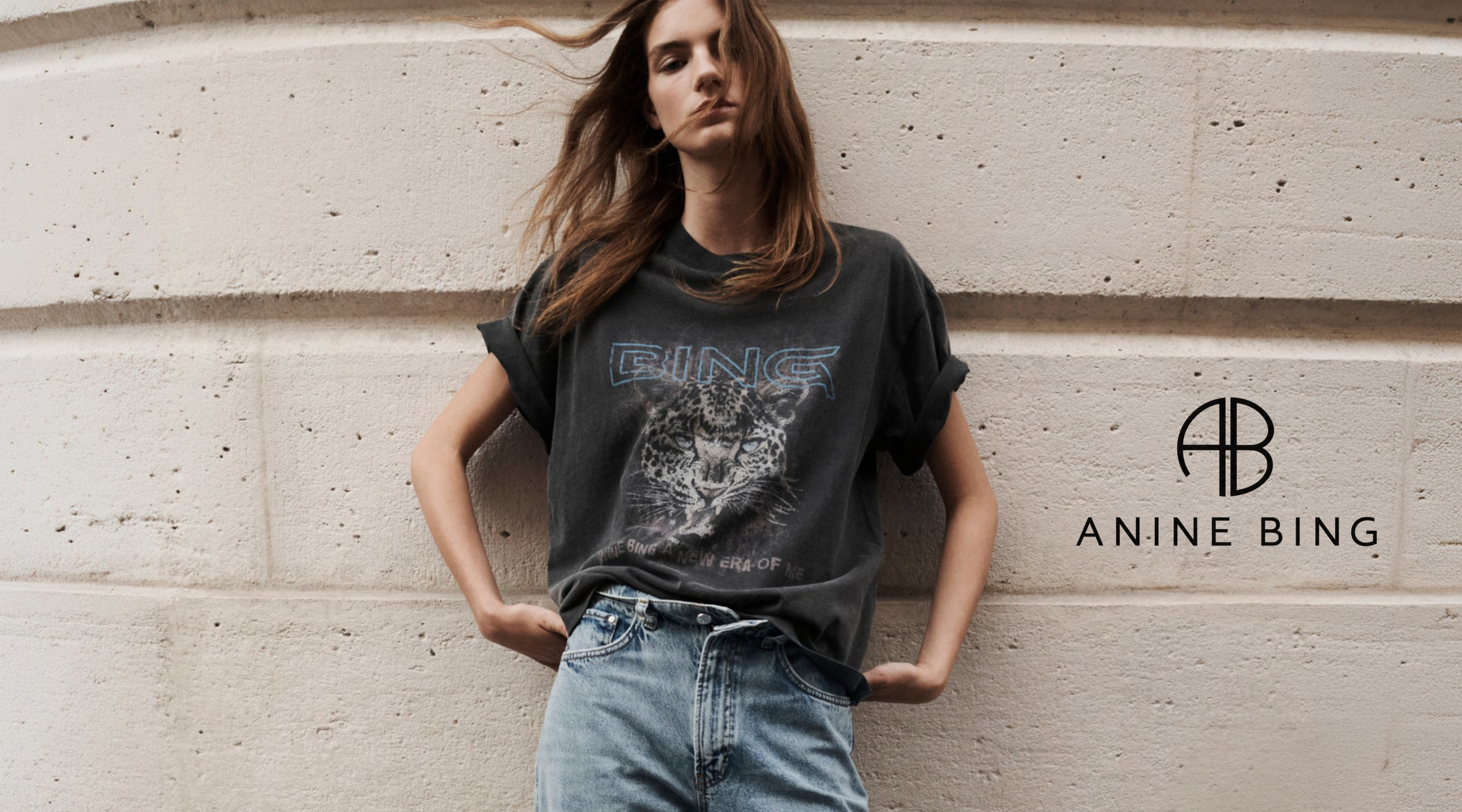 frau mit einem anine bing t-shirt vor einer hauswand