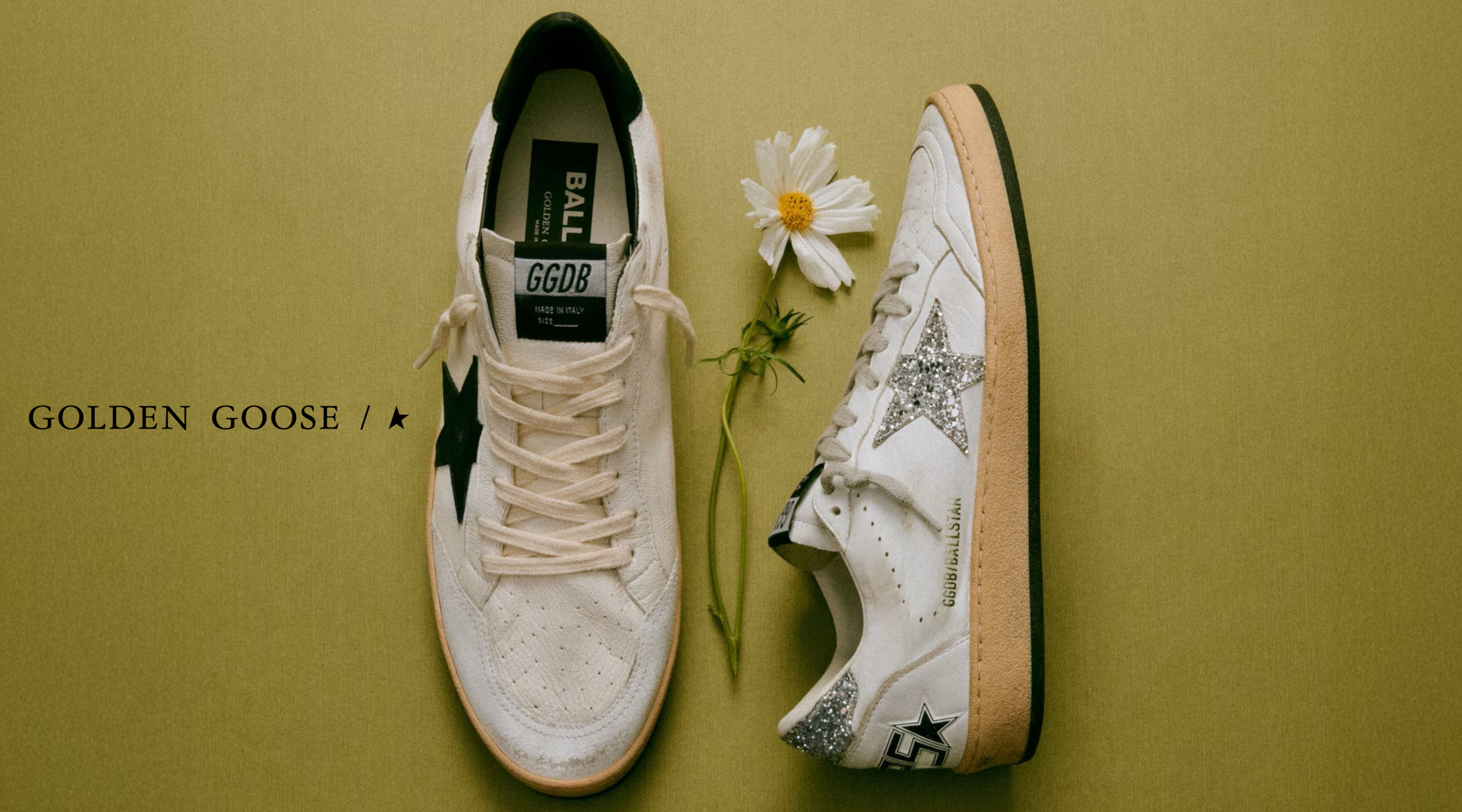 zwei golden goose sneaker mit einer blume dekoriert