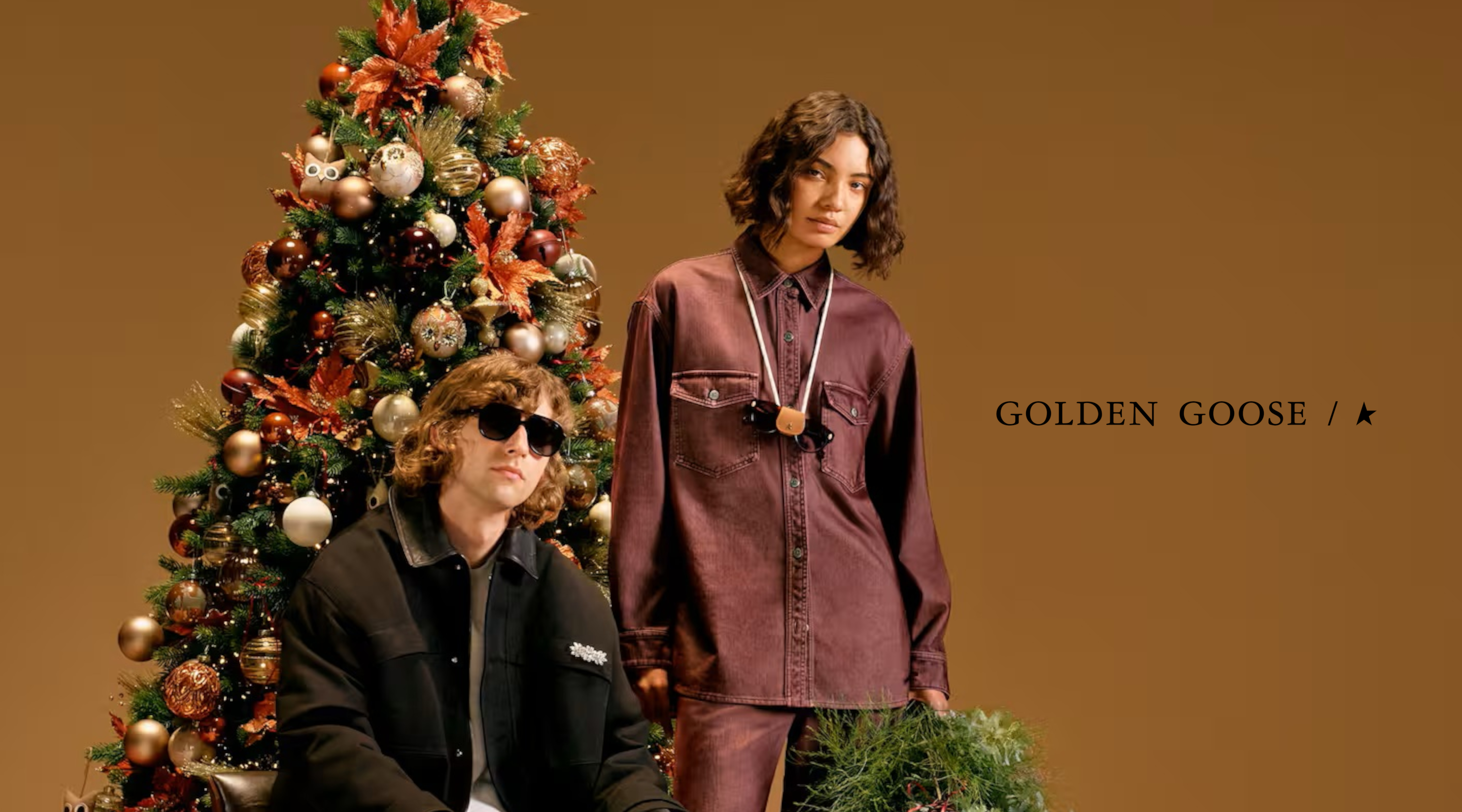 zwei menschen die vor einem weihnachtsbaum stehen